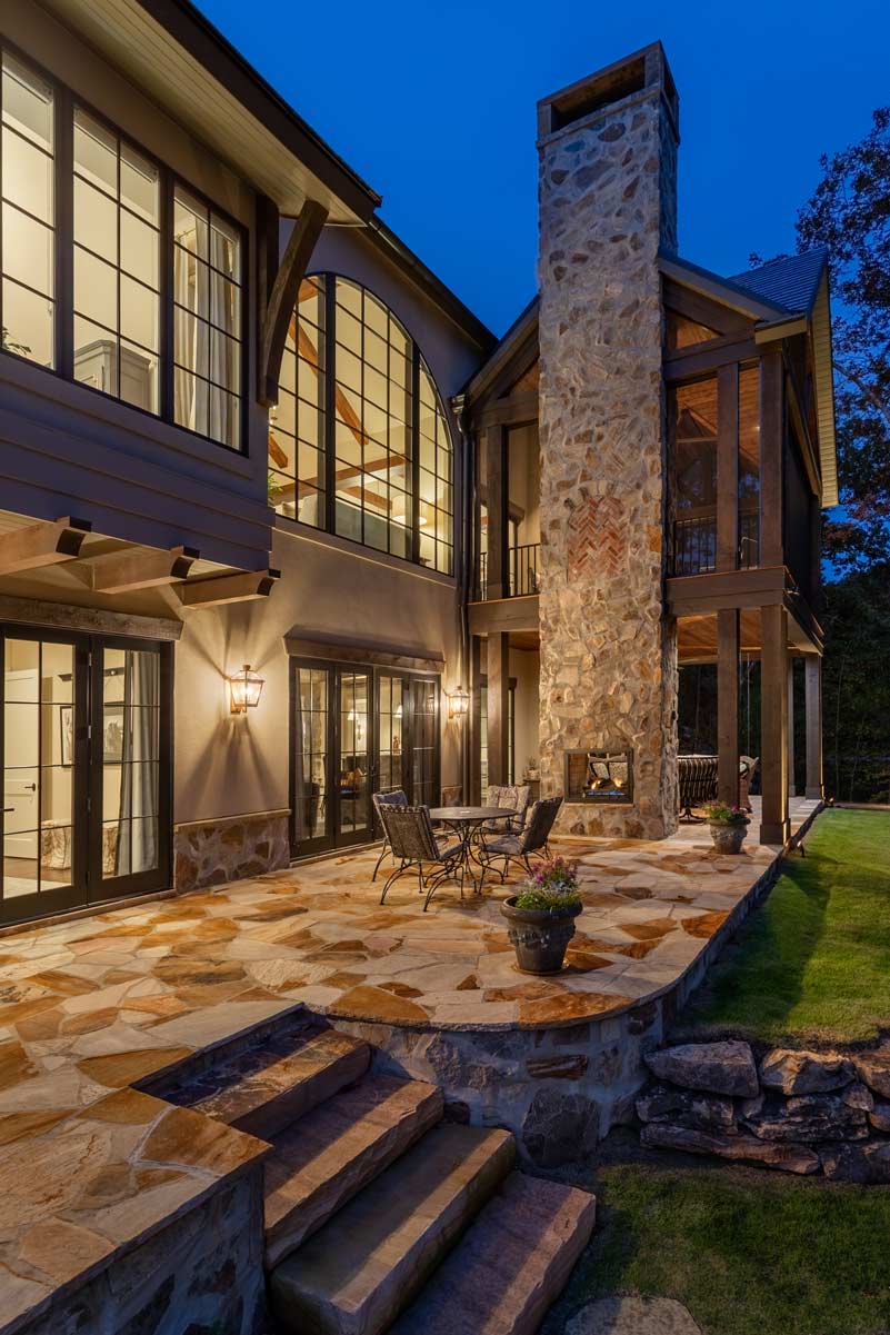 The rear of the home seen at night with stonework