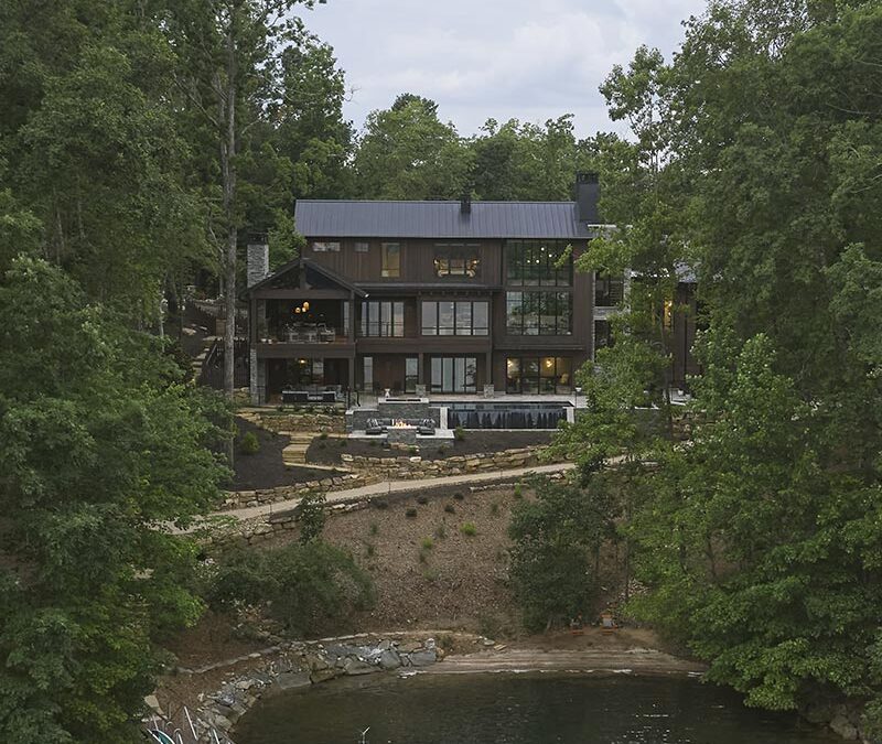 Aerial photo from the lake, showing the dock, pool and exterior of the home