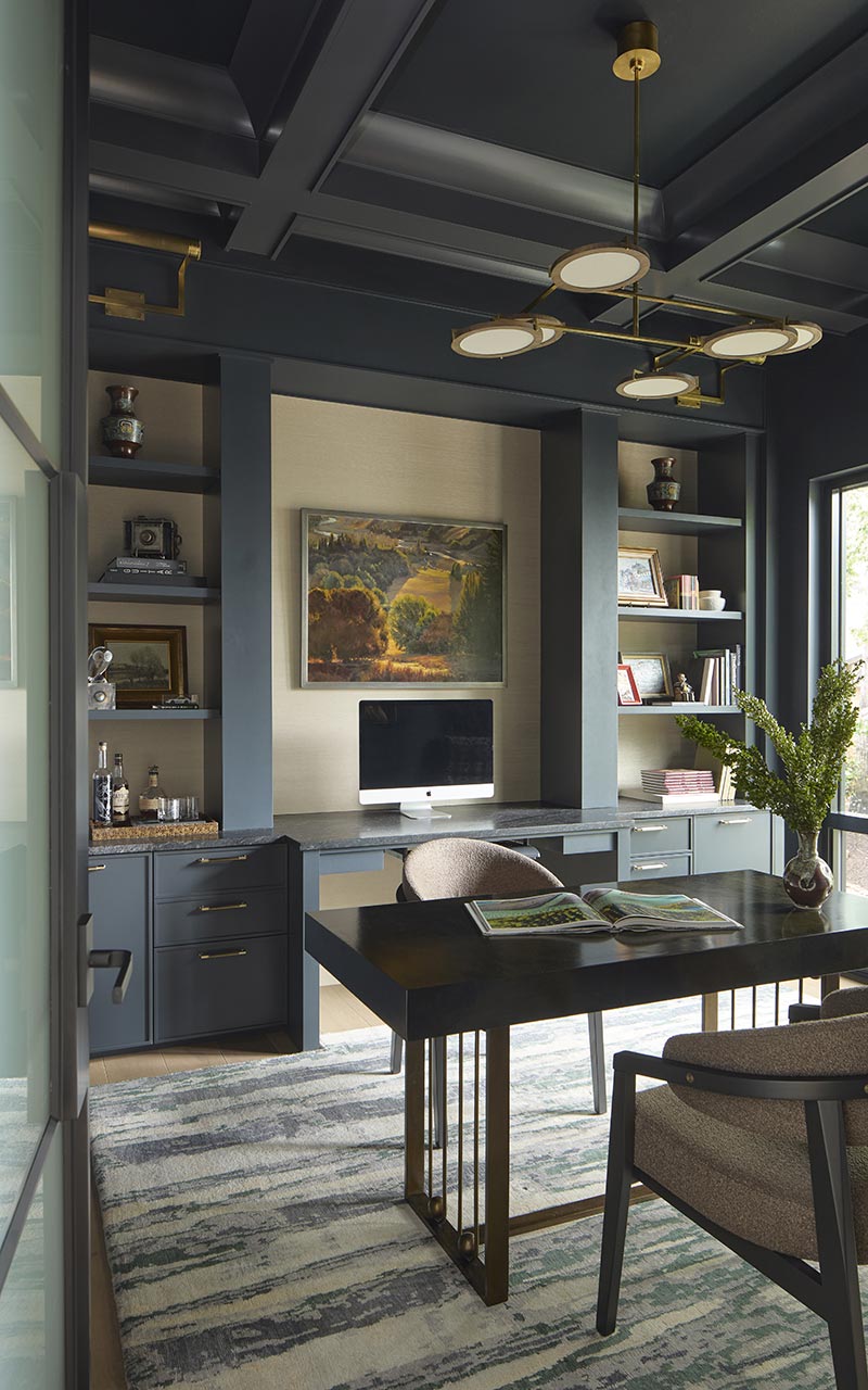 Home study with muted dark colors and custom cabinetry with coffered ceiling
