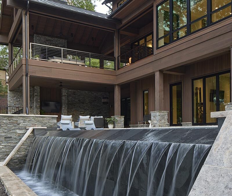 Home exterior showing landscaping and infinity pool with waterfall
