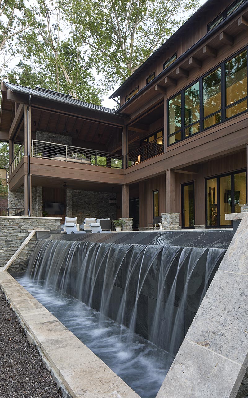 Home exterior showing landscaping and infinity pool with waterfall